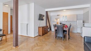 Un apartamento moderno con comedor, cocina y un gran pilar de madera.