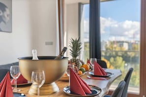 A dining table set with a gold bowl, red napkins, and a glass. - Terrace ONE (Prague 7)