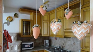 Una cucina con mobili in legno, un forno a microonde, una macchina da caffè e decorazioni appese.