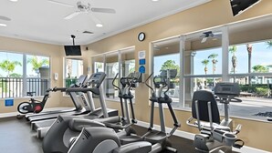 Et fitnesscenter med løbebånd, crosstrainere og en motionscykel.
