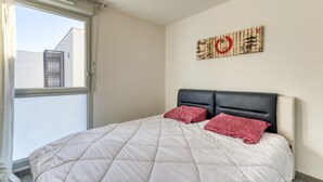 A bedroom with a bed, a window, and a wall-mounted artwork. - Illiade Room in Shared Villa with Pool and Terrace (Jacou)