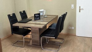 Ein Essbereich mit einem Holztisch, schwarzen Stühlen und einem Schild mit der Aufschrift 'Relax'.