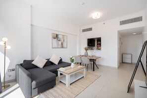 Apartament de luxe, balcó, vistes a la ciutat | Sala d'estar | Televisor intel·ligent de 65 polzades amb canals per cable 