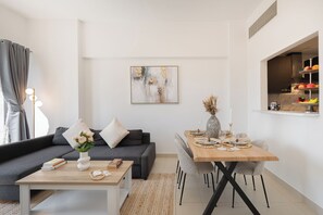 Apartament de luxe, balcó, vistes a la ciutat | Sala d'estar | Televisor intel·ligent de 65 polzades amb canals per cable 