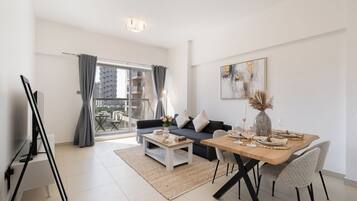 Luxury-Apartment, Balkon, Stadtblick | Wohnbereich | 65-Zoll-Smart-TV mit Kabelempfang