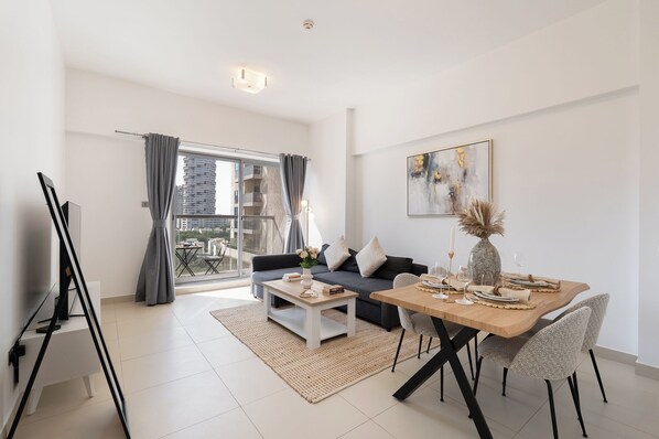 Luxury-Apartment, Balkon, Stadtblick | Wohnbereich | 65-Zoll-Smart-TV mit Kabelempfang