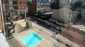 Ein Hochhaus mit Pool und Lounge-Bereich auf dem Dach.