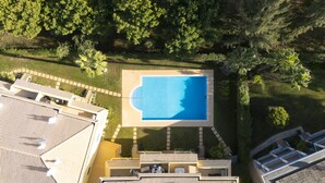 An aerial view of a residential area with a swimming pool surrounded by greenery and a tiled roof. - Mar e Golfe - Pool with golf view by HD (Vilamoura)