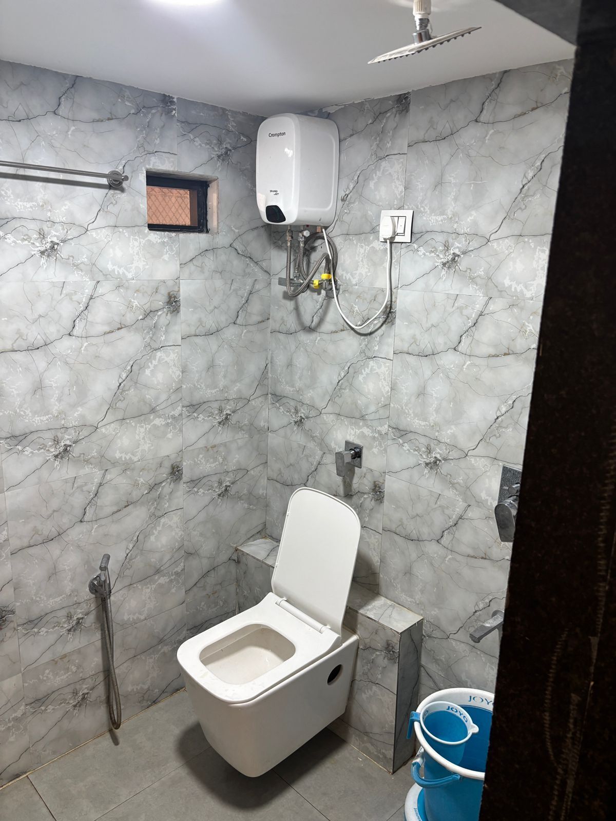 Un baño con inodoro, ducha y secamanos.