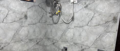 Une salle de bain équipée de toilettes, d’une douche et d’un chauffe-eau.