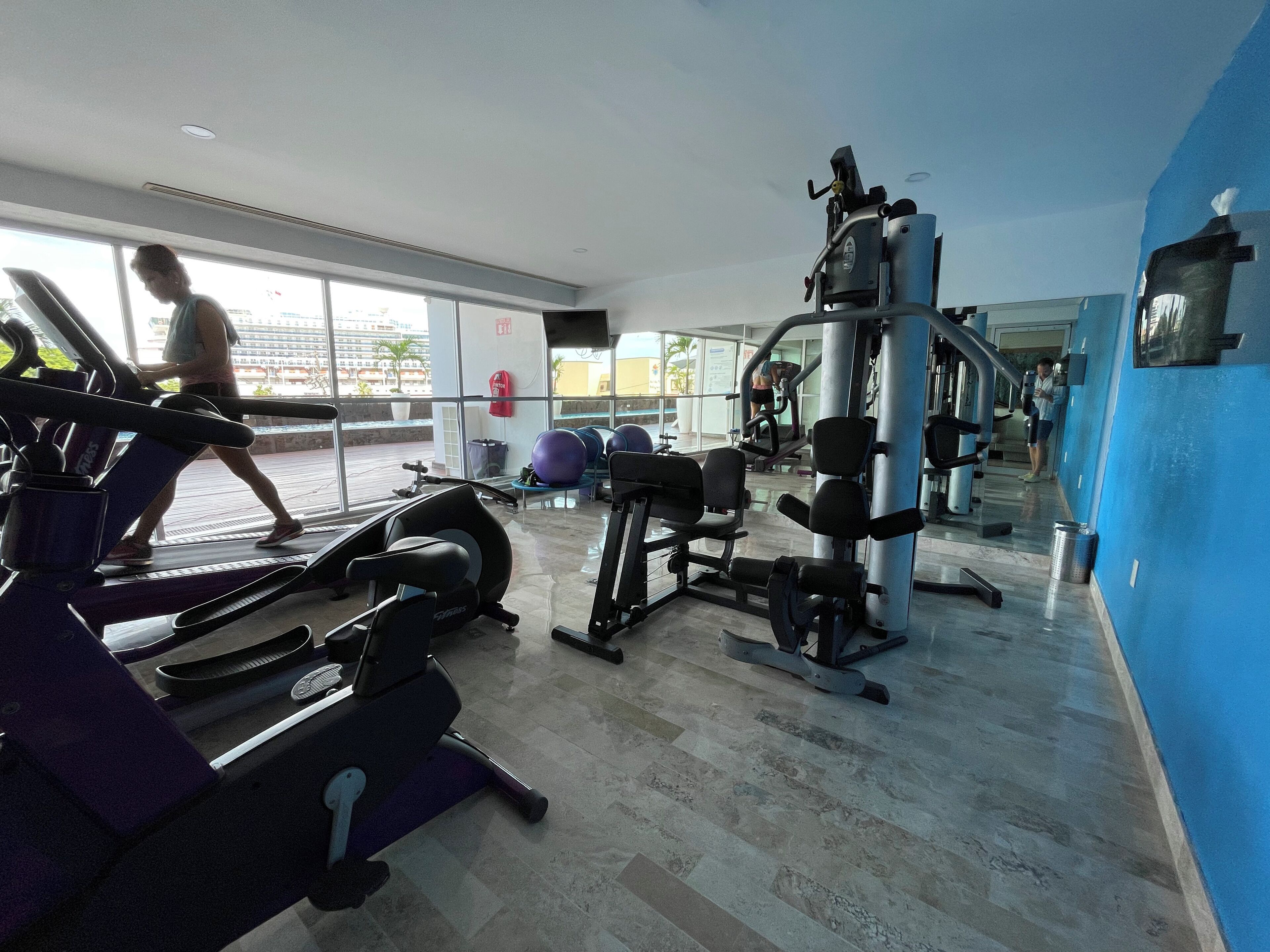 A gym with treadmills, exercise balls, and weight machines.