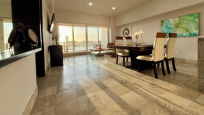 A spacious living area with a large dining table, comfortable seating, and a view of the outdoors. - Deck 12 Vallarta Residences (Puerto Vallarta)