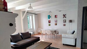 A living room with a sofa, a coffee table, a dining table with chairs, and artwork on the walls. - Ideal for a large family, authentic Landes house, pets welcome (Biscarrosse)