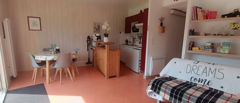 Una habitación acogedora con comedor, kitchenette y cama con almohada motivacional.