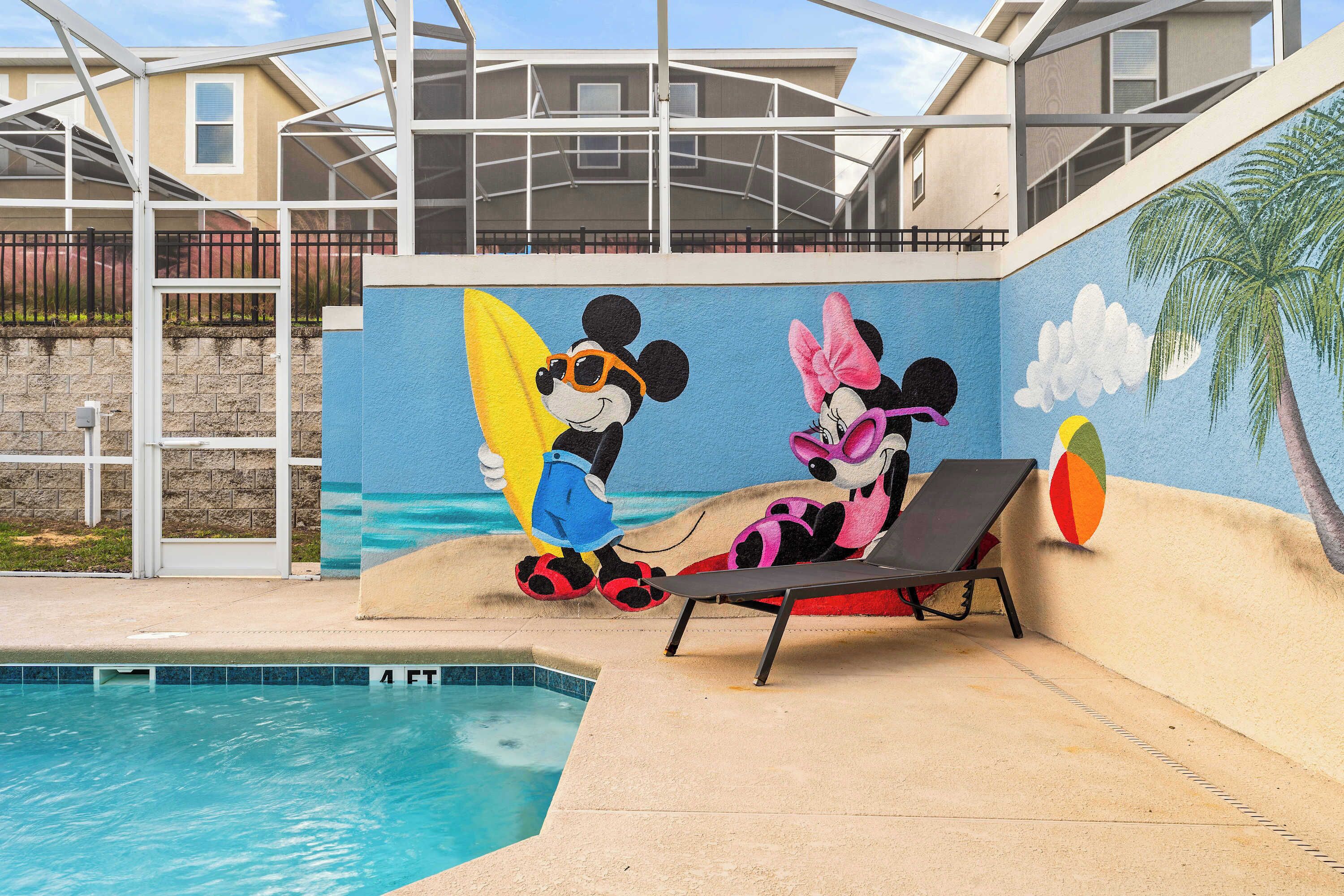 Ein Poolbereich mit Wandgemälde von Mickey und Minnie Maus, einer Liege und einer Palme.