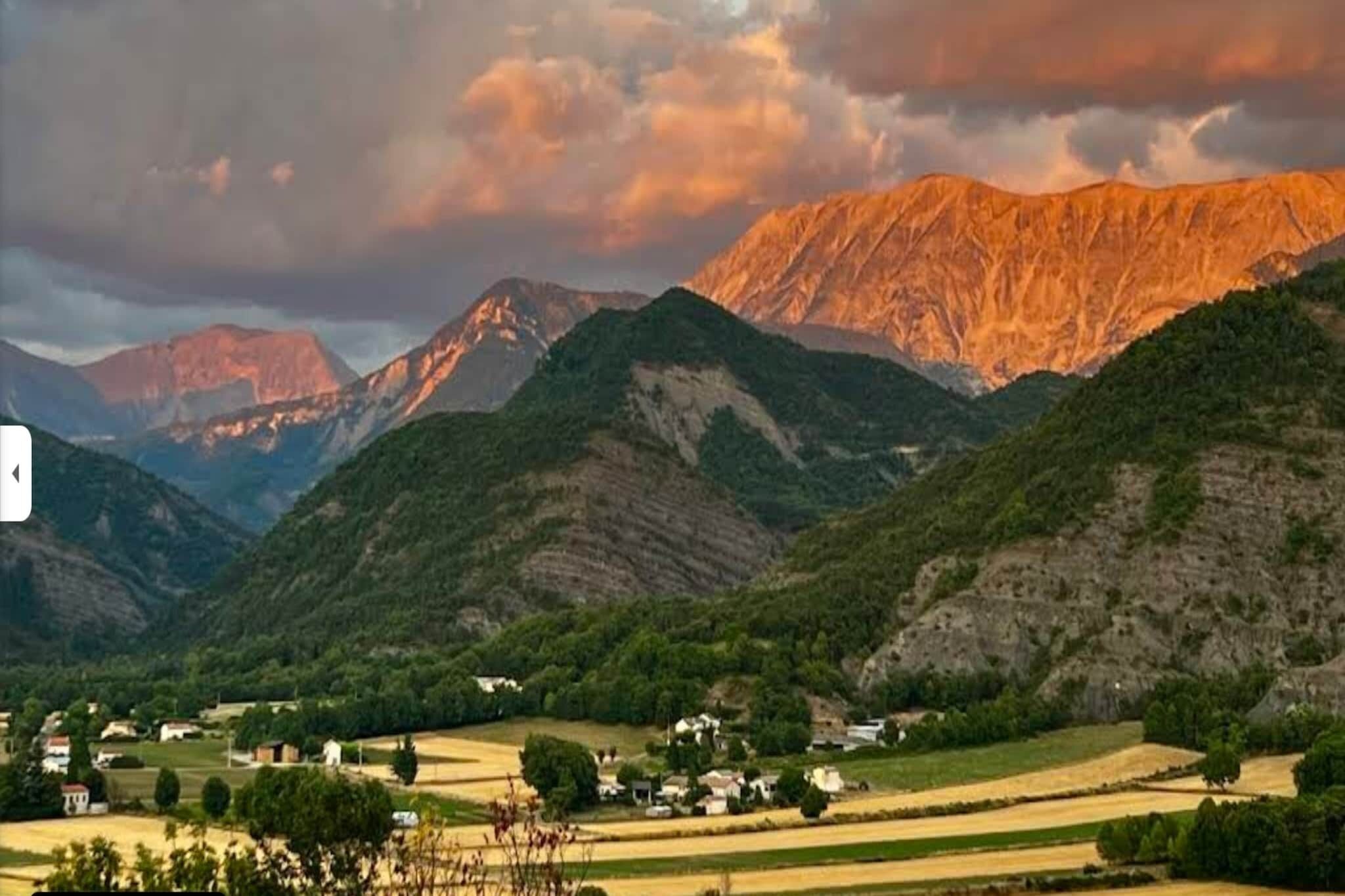 Een bergachtig landschap met een dorpje verscholen tussen de heuvels.