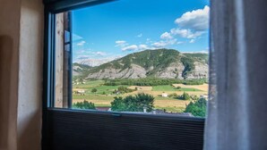 Vista desde una ventana a un paisaje montañoso con cielo despejado.