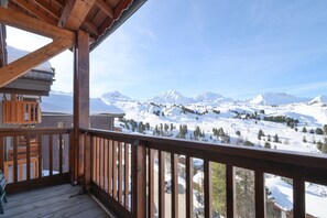 A wooden balcony with a view of snow-covered mountains and a clear sky. - Spacious Chalet-Style Triplex Apartment for 10 in Belle Plagne, Ski-In/Ski-Out (La Plagne Tarentaise)
