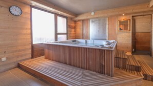 A wooden interior with a wooden bench, a glass enclosure, and a clock on the wall. - Spacious Chalet-Style Triplex Apartment for 10 in Belle Plagne, Ski-In/Ski-Out (La Plagne Tarentaise)