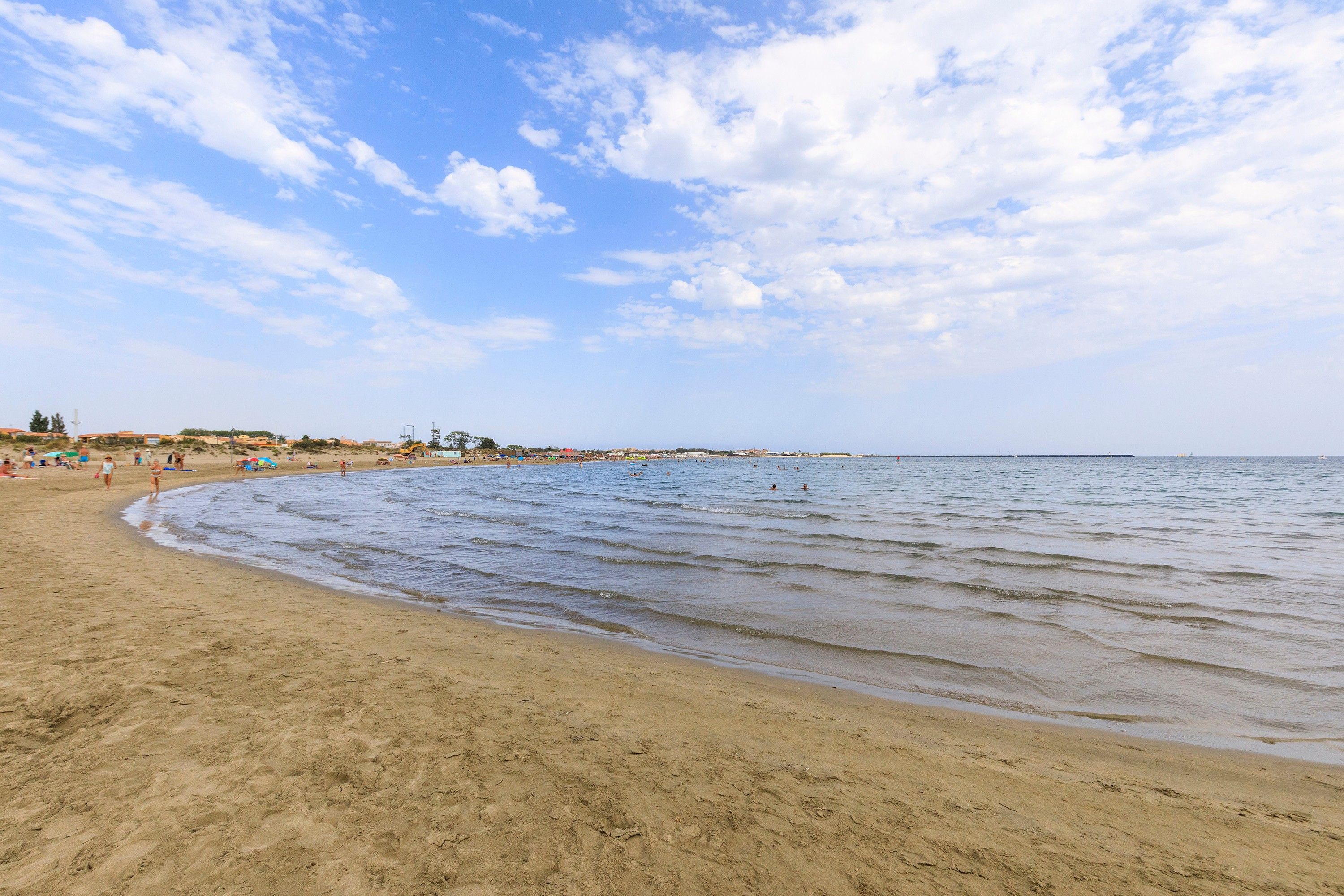 A beach with a sandy shore and a clear sky.