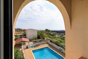En swimmingpool med utsikt över ett bostadsområde och en bro i fjärran.