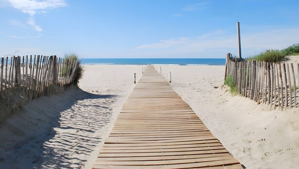 A wooden boardwalk leading to a beach with a clear sky. - Apartment 'Cap d'Agde - Primavera - 2' with Sea View, Shared Pool and Air Conditioning (Agde)
