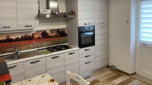 A modern kitchen with white cabinetry, a built-in oven, a gas stove, and a decorative backsplash. - Between S. Gimignano and Volterra in the peace of the woods of Tuscany (Gambassi Terme)