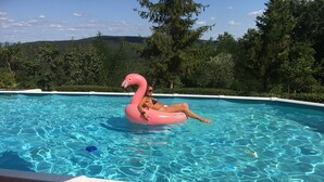 A swimming pool with clear blue water, surrounded by a brick deck and greenery. - Between S. Gimignano and Volterra in the peace of the woods of Tuscany (Gambassi Terme)
