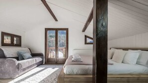 Un dormitorio con una cama, un sofá y un ventanal grande.
