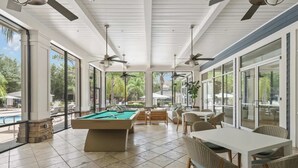 A pool area with a pool table, chairs, and a dining table. - Peaceful 2 BR with Private Garage, Prime North Tampa (Lutz)
