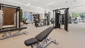 A gym with various exercise equipment, a bench, and large windows offering natural light. - Peaceful 2 BR with Private Garage, Prime North Tampa (Lutz)