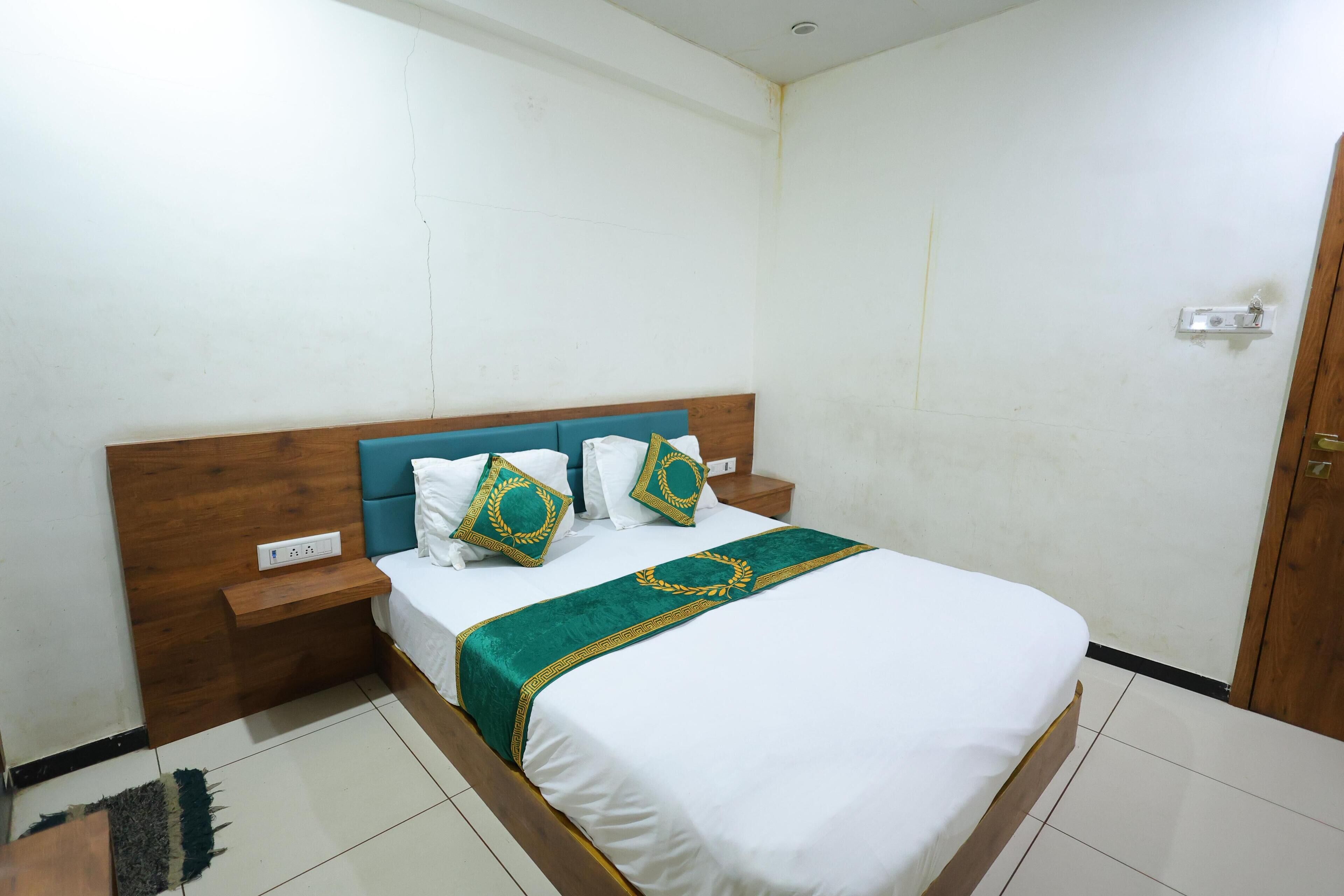 Una cama bien hecha con cabecera de madera, ropa de cama blanca y almohadas decorativas.