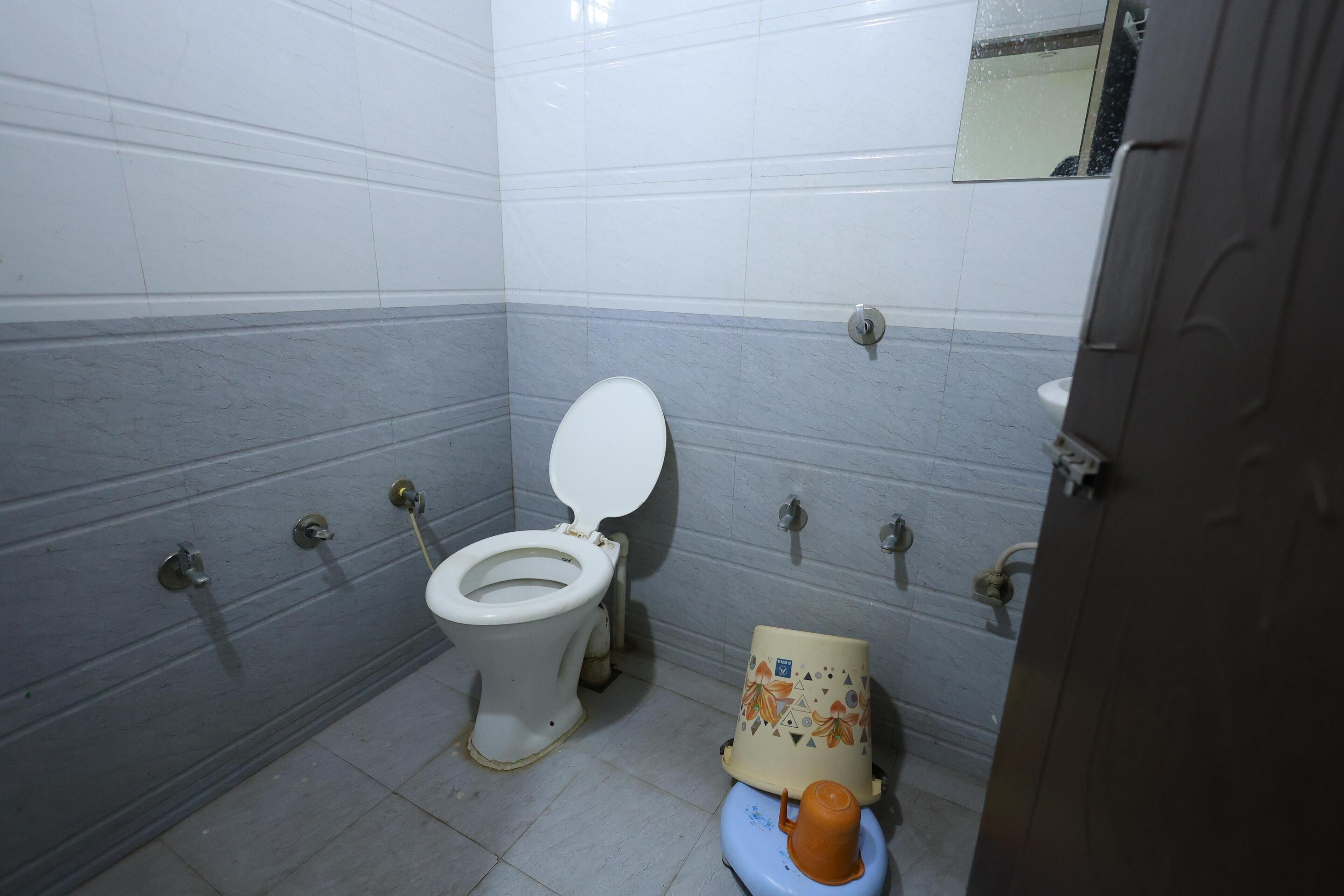 Un baño con inodoro, lavamanos y espejo.