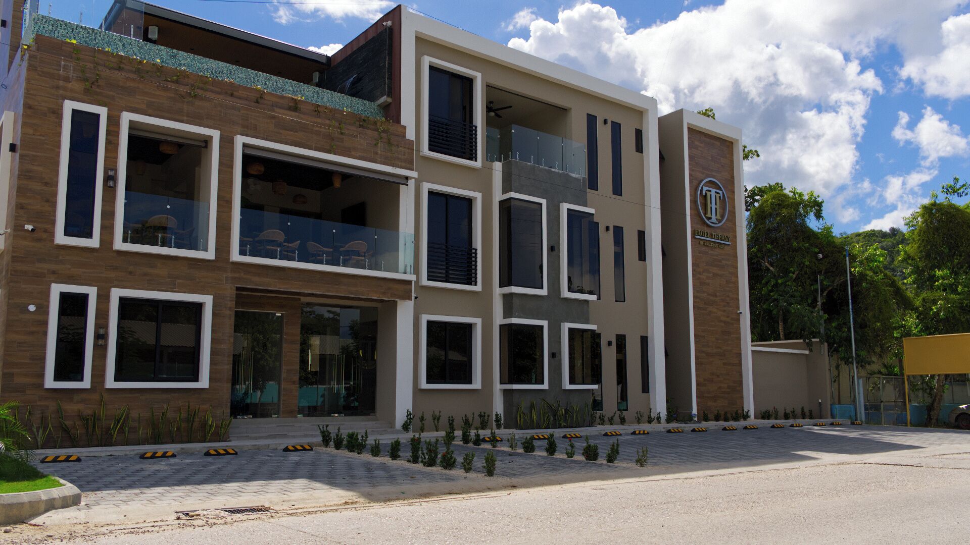 A modern hotel with a two-story structure, large windows, and a balcony.