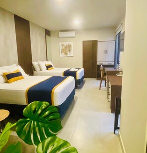 A hotel room with two beds, a small kitchenette, and a dining area. - Hotel Tiffany (Flores)