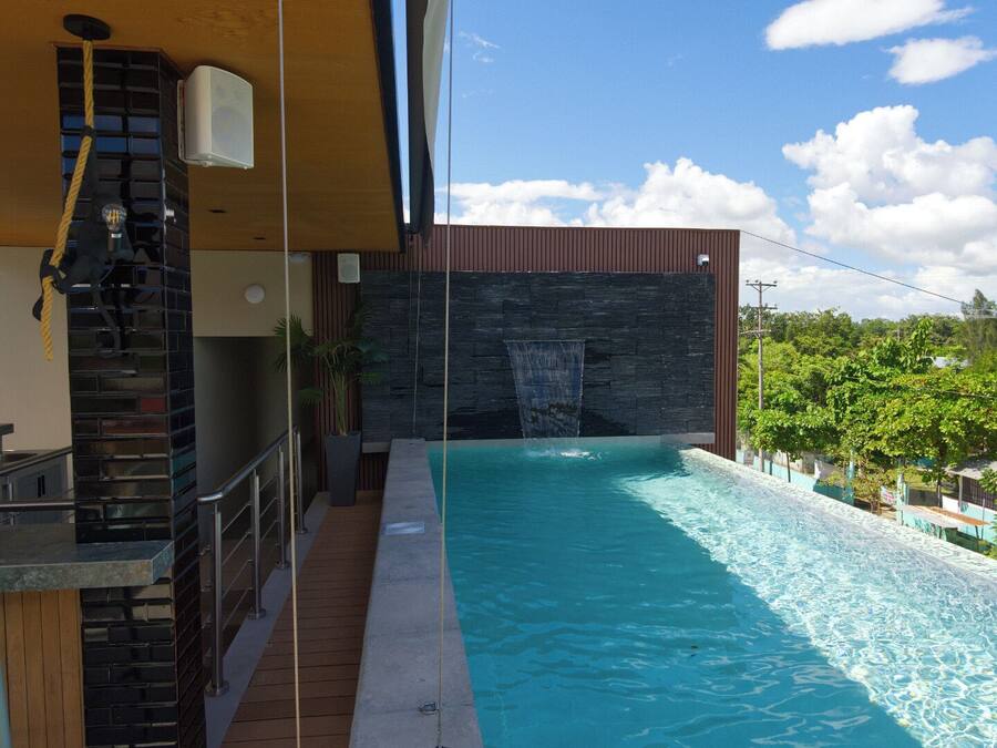 Un edificio moderno con piscina, una escalera y vistas del entorno.