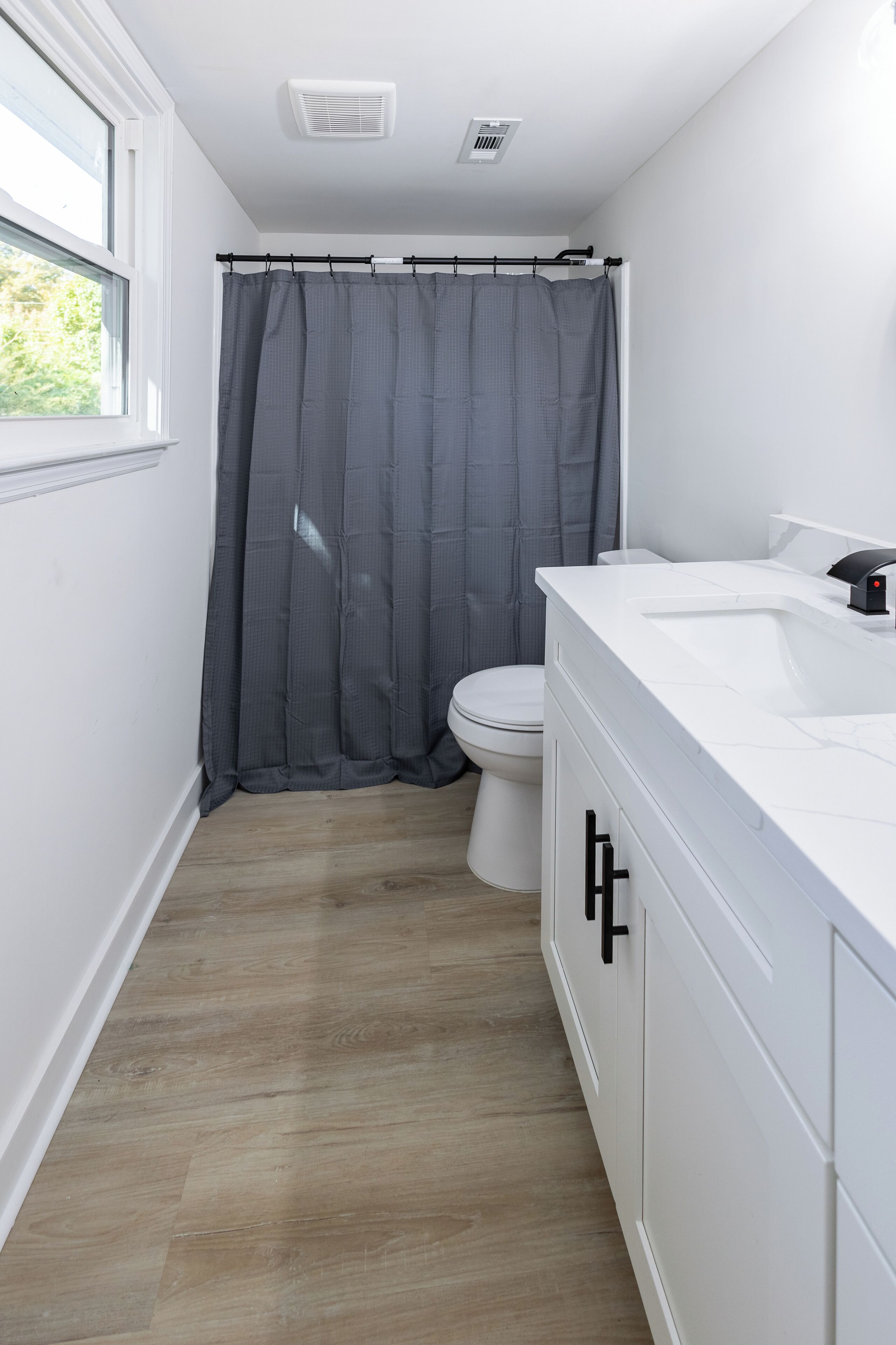 Ein modernes Badezimmer mit Waschbecken, Toilette und Duschvorhang.
