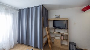 Ett rum med ett skrivbord i trä, en tv och en stege.