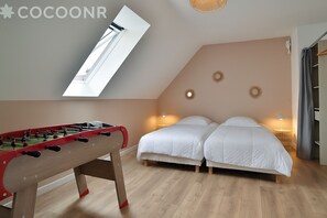 A bedroom with a foosball table, two beds, and a skylight. - Ker Ostrea - Moins d'un km de la plage (Cancale)