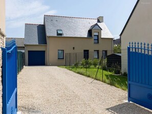 A two-story house with a gravel driveway, a blue gate, and a small garden. - Ker Ostrea - Moins d'un km de la plage (Cancale)