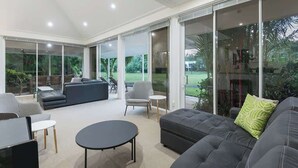 A spacious living area with a sofa, armchairs, and a coffee table.
