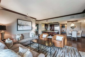 A spacious living room with a sofa set, a coffee table, and a dining area with chairs and a table. - Three-Bedroom · 3.5 Bath · Valley View · Sleeps 8 (Truckee)