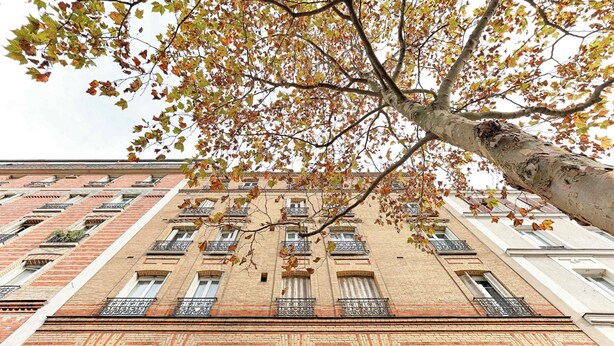 A multi-story building with a brick facade, multiple windows, and balconies. - Cosy Studio Asnieres (Asnières-sur-Seine)