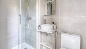 A modern bathroom with a glass-enclosed shower, a white sink, and a toilet. - Modern Studio Near Paris w/ Fast WiFi, TV (Charenton-le-Pont)