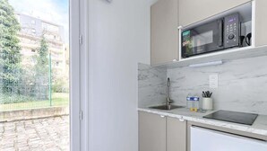 A modern kitchen with a built-in microwave, a sink, and a refrigerator. - Modern Studio Near Paris w/ Fast WiFi, TV (Charenton-le-Pont)