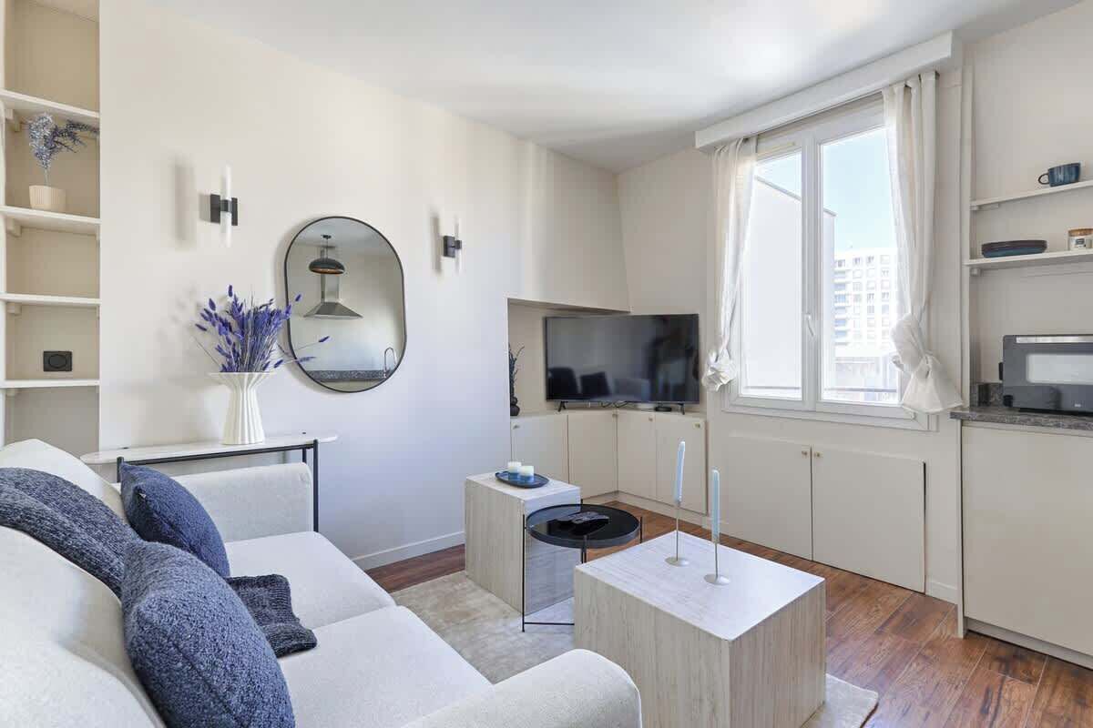 Un salon moderne comprenant un canapé, une table basse, un téléviseur et une petite table d’appoint.