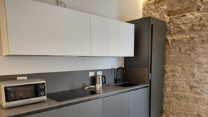 A modern kitchen with a built-in microwave, a coffee maker, and a sink.