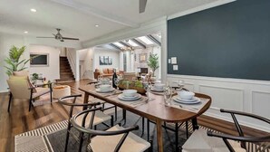 A spacious dining area with a long wooden table set for a meal, surrounded by modern chairs. - ALL Kings!/ Gameroom/ Huge Deck/ Family Friendly (Norcross)