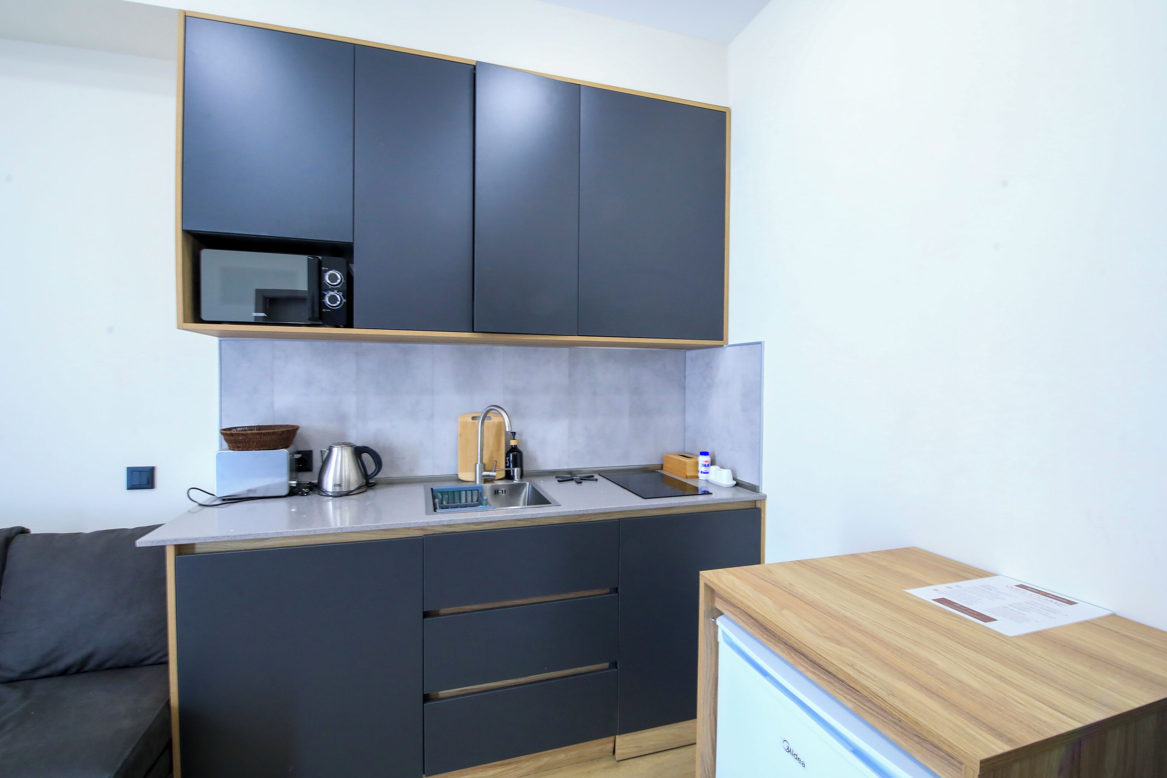 A compact kitchen with dark cabinets, a sink, and a small countertop.