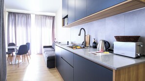 Een moderne keuken met een inbouwtoaster, een waterkoker en een mand op het aanrecht.